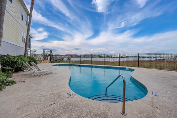 Inviting waterfront townhouse with beach access, balcony, W/D, pool & dock